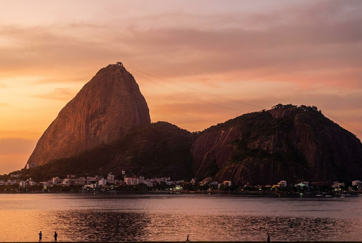 Sugarloaf Mountain glowing orange at sunset over Guanabara Bay in Rio de Janeiro