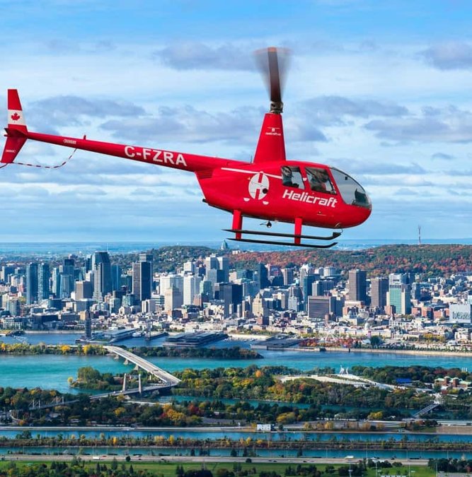 Red helicopter flying above the Montreal skyline