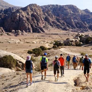 Hikers on a rocky trail in the Dana reserve heading toward Petra