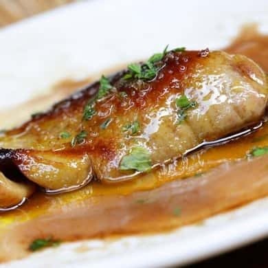 Pintxo of seared fish on a plate in a San Sebastián bar