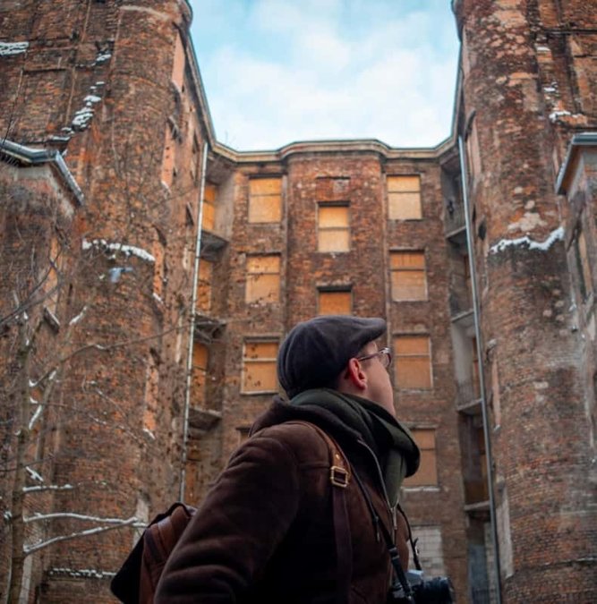 Guide beside a surviving brick wall of the Warsaw Ghetto
