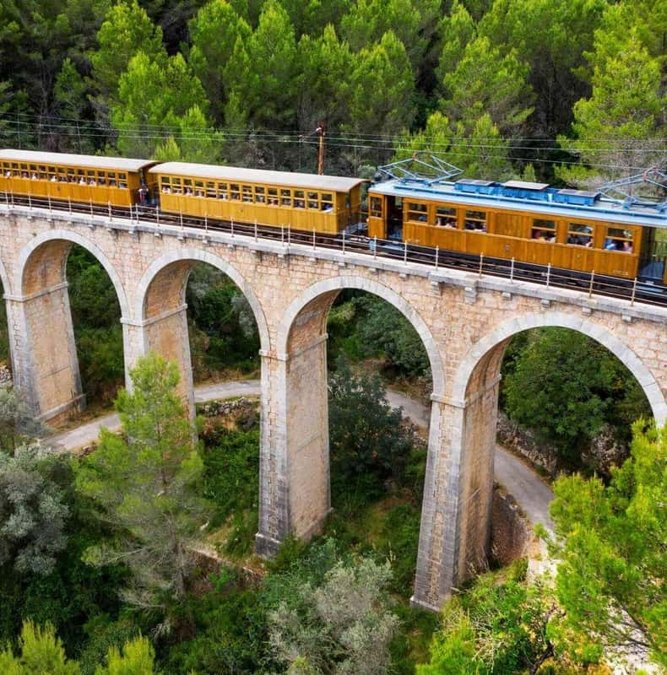 Vintage Sóller train crossing a stone viaduct