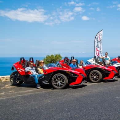 Red three-wheeled formula car on a Mallorca coastal road