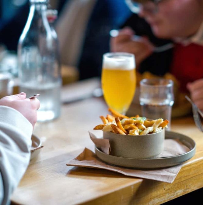 Poutine and a beer on a Montreal café table