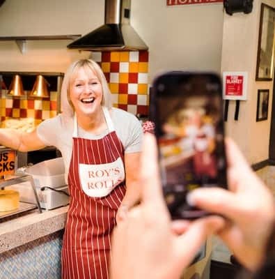 Smiling woman in an apron on the Coronation Street set