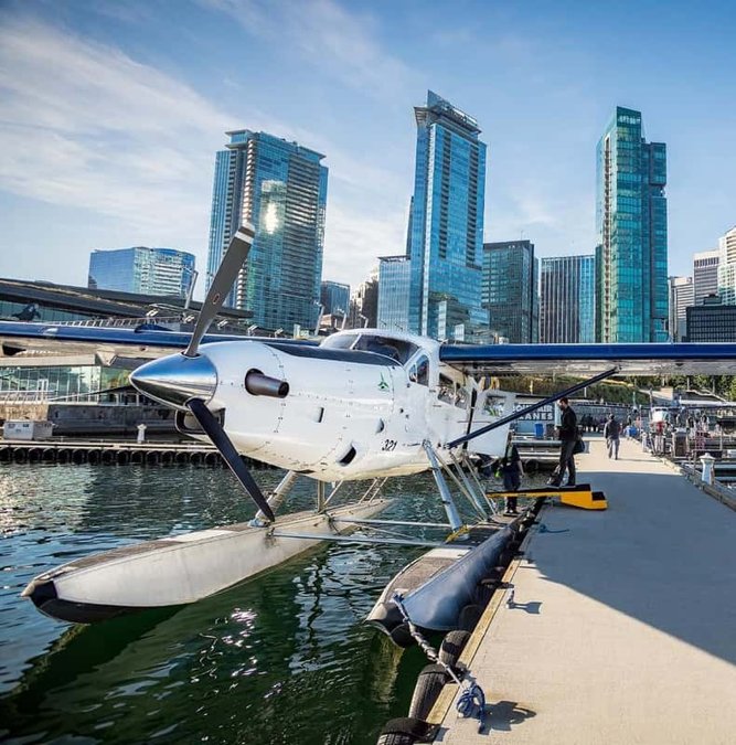 Seaplane docked in Coal Harbour with the Vancouver skyline behind
