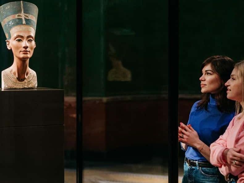 Visitors looking at the bust of Nefertiti in the Neues Museum, Berlin