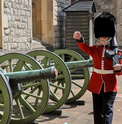 Yeoman Warder beside a cannon at the Tower of London