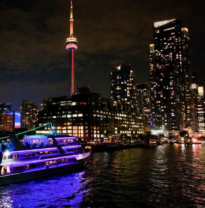 Toronto skyline lit up at night from a dinner cruise
