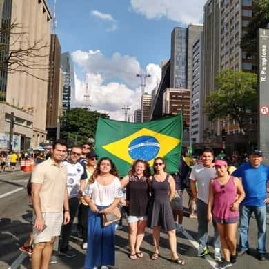 Group holding a Brazilian flag on a São Paulo city tour