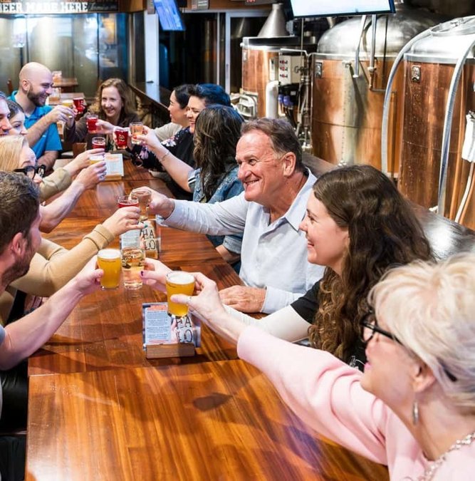 Group toasting with beer flights on a Gastown food tour