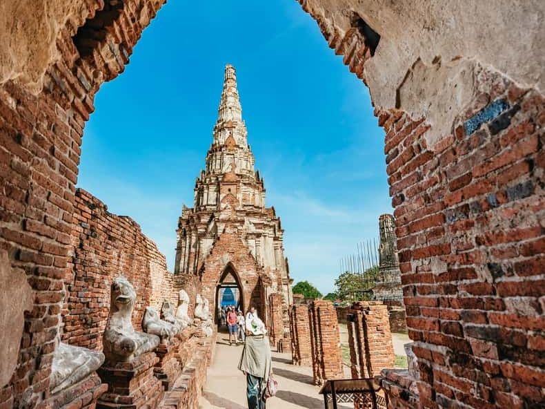 A brick temple tower framed by an arched doorway in Ayutthaya