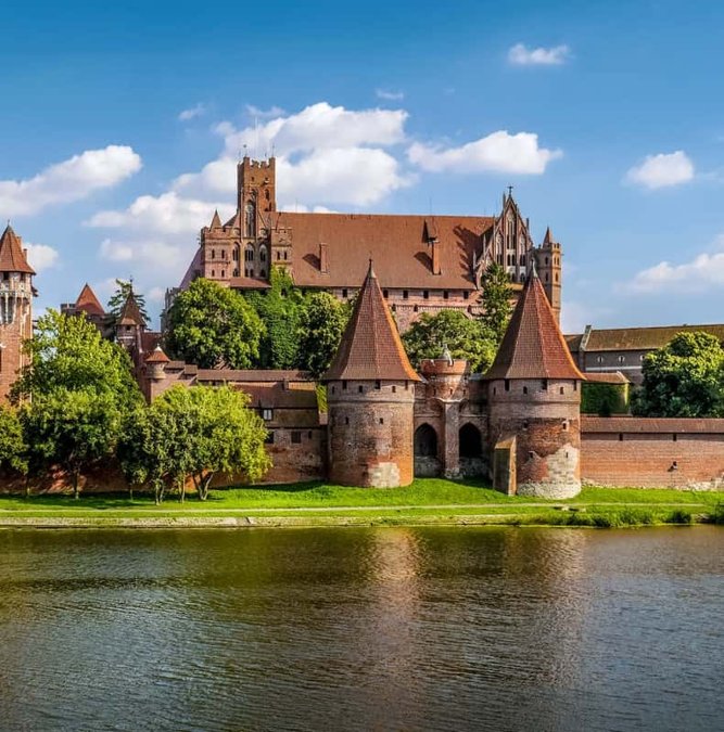 Red-brick Malbork Castle reflected in the Nogat river