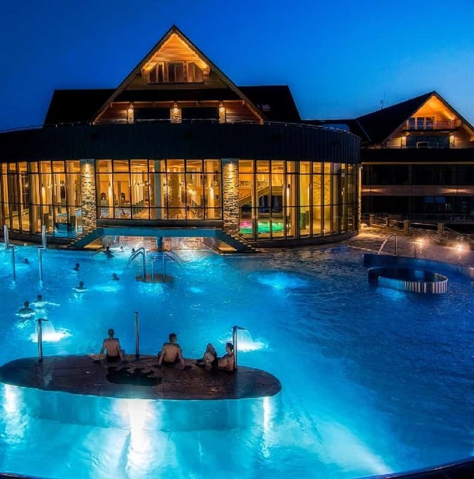 Outdoor thermal pools of Chochołów lit at night