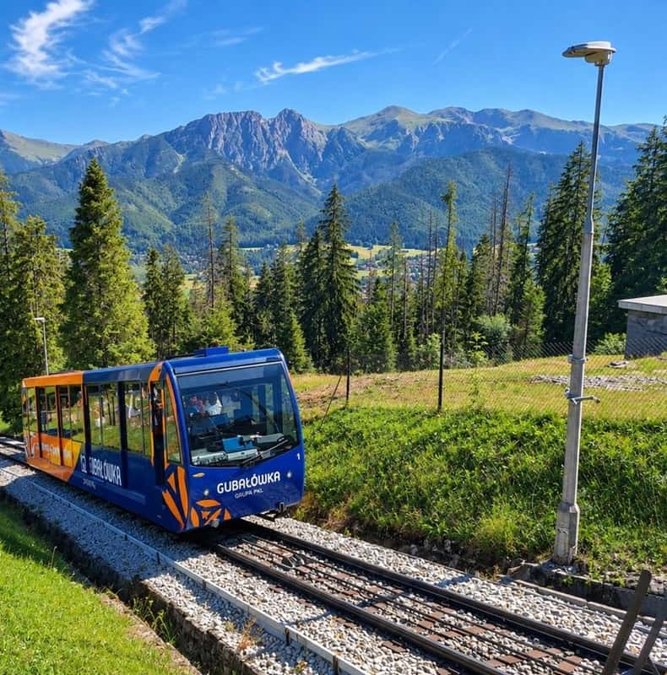Gubałówka funicular car climbing above Zakopane with the Tatras behind