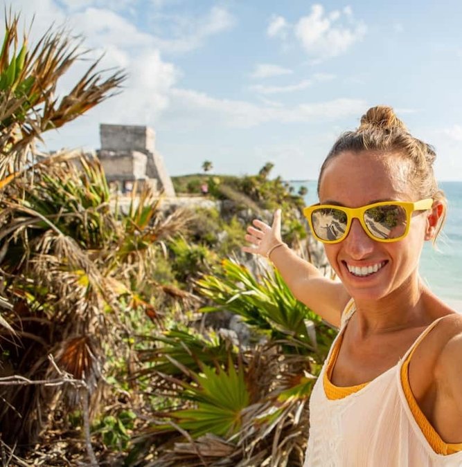 Traveler smiling in front of the Tulum ruins