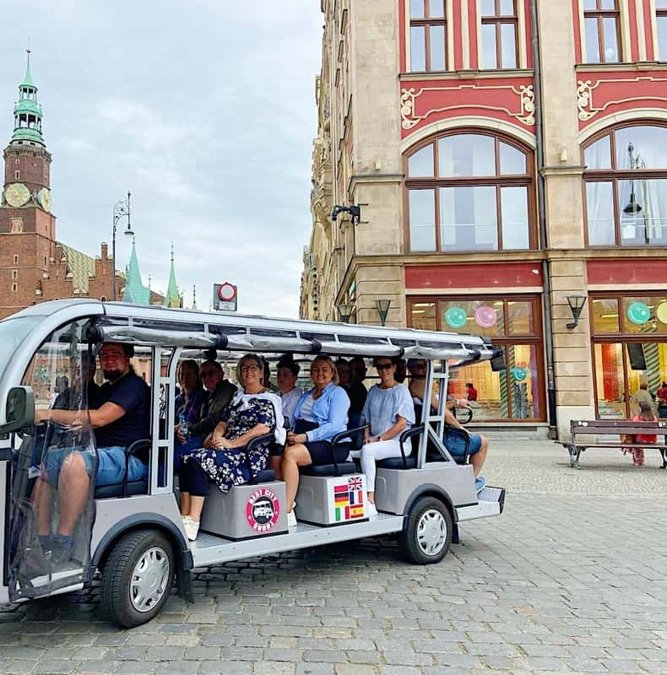 Electric sightseeing car with passengers on the Wroclaw Market Square