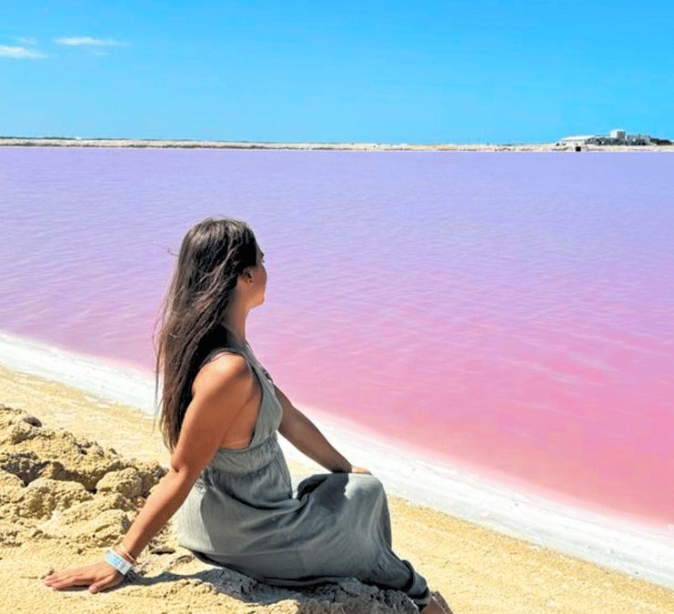 Traveler sitting beside the pink lake of Las Coloradas