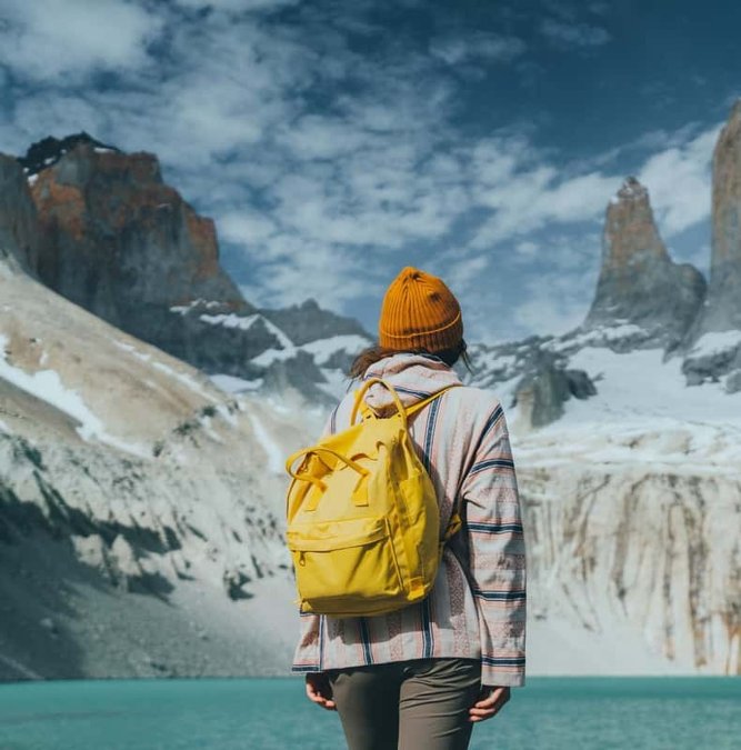 Hiker with a yellow backpack at the Base of the Towers lake