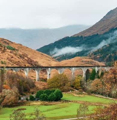 The curved Glenfinnan Viaduct among autumn hills in the Highlands