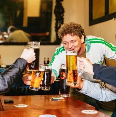 Friends clinking beer steins in a Munich beer hall