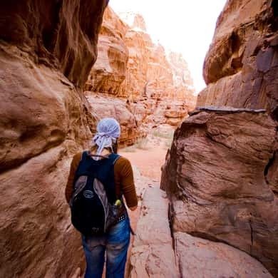 Hiker climbing a sandstone outcrop in Wadi Rum