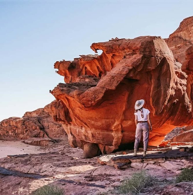 Guide beside a wind-carved rock formation in Wadi Rum