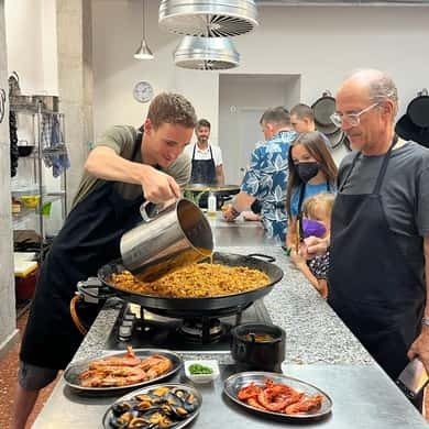 Chef stirring a paella pan in a cooking class