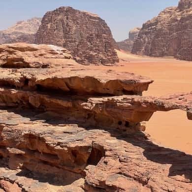 Jeep tracks across the red sand between the cliffs of Wadi Rum