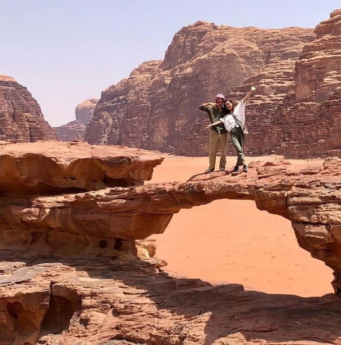 Traveler standing on a natural rock bridge in Wadi Rum