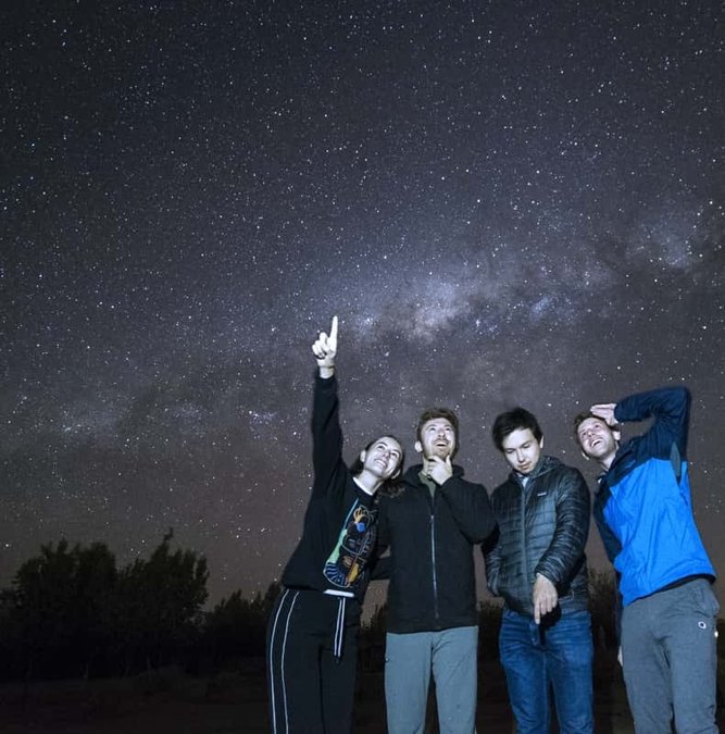 Group pointing at the Milky Way over the Atacama