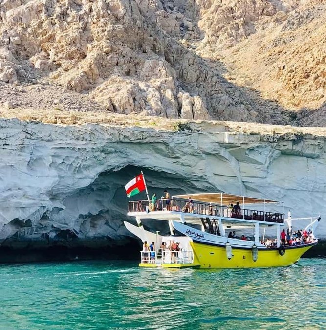 Dhow boat in a turquoise inlet of the Musandam coast