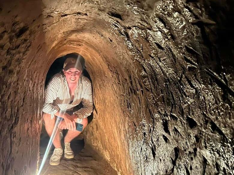A visitor crawling through a narrow tunnel at Cu Chi