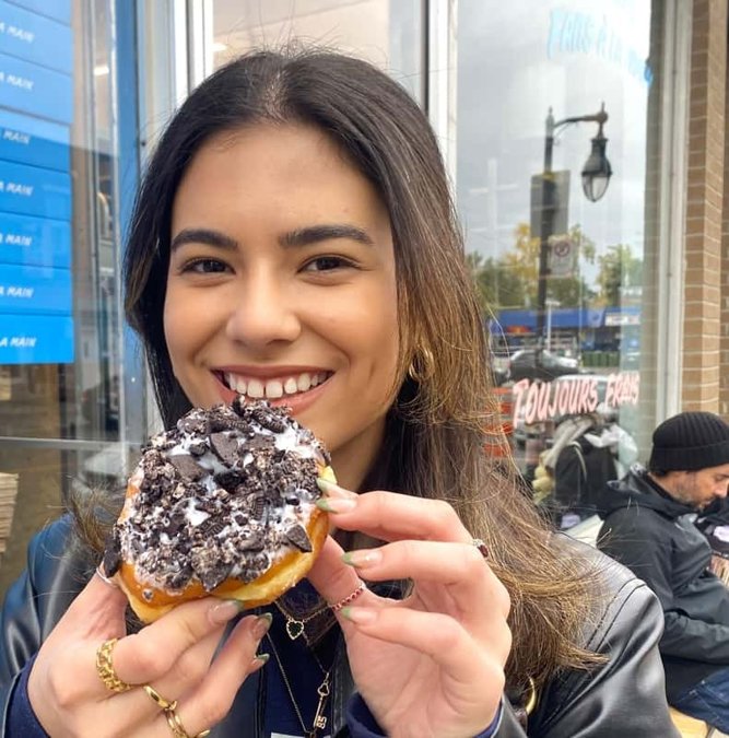 Traveler holding a chocolate-dipped treat on a Mile End food tour