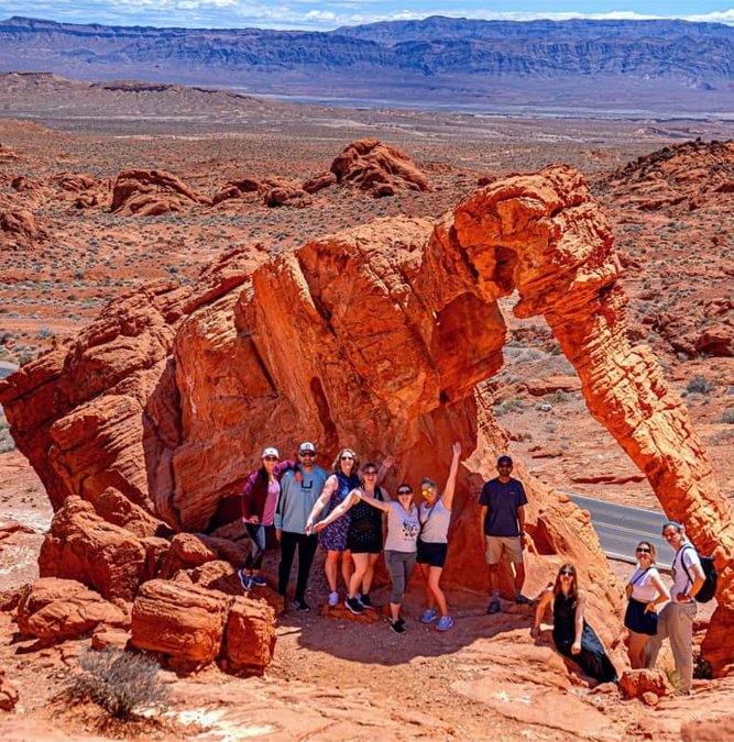 Group under a red sandstone arch in Valley of Fire