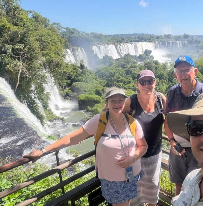 Travelers on the walkway with Iguazu Falls behind