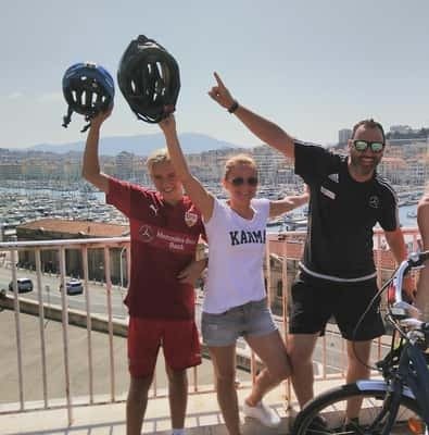 Group of cyclists in helmets cheering above Marseille