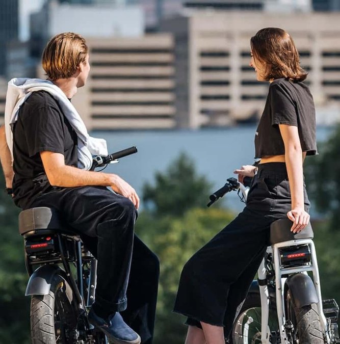 Riders on e-bikes with the Montreal skyline behind