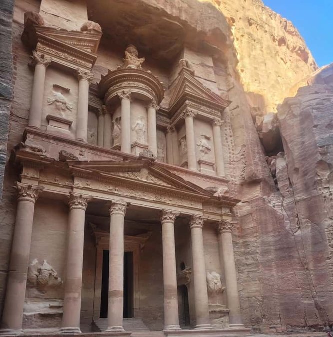 Guide and visitors walking through the Siq at Petra