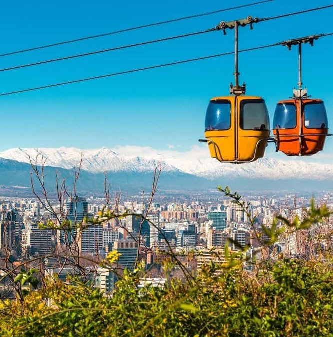 Cable car cabins over Santiago with the Andes behind
