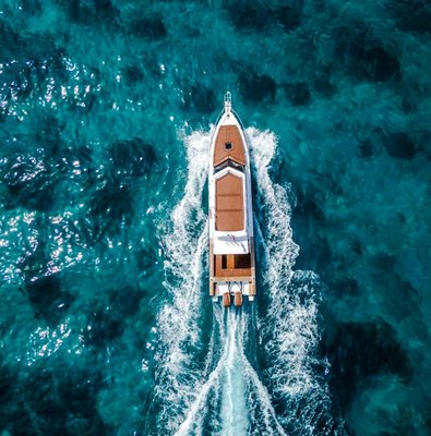 Boat cruising on clear blue waters near West Nusa Penida Island.