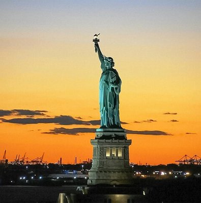Statue of Liberty at sunset during Ellis Island sightseeing cruise.