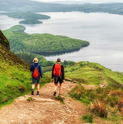 Hikers on a trail overlooking Loch Lomond, Scotland.