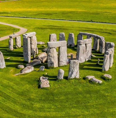 Tourists walking around Stonehenge on a day trip from London.