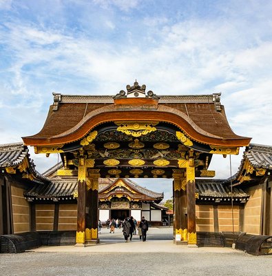 Entrance gate of Nijo Castle in Kyoto, Japan, with ornate wooden carvings and gold accents.