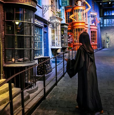 Person in robe with wand on Diagon Alley at Harry Potter London tour.