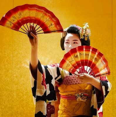 Geisha performing with fans in traditional attire, Kyoto.