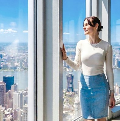 Person enjoying city view from Empire State Building observatory in New York City.