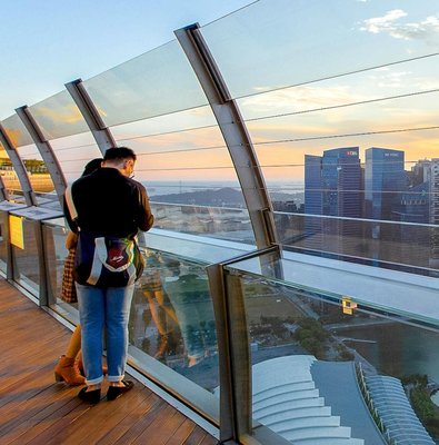 Couple enjoying city view from Marina Bay Sands SkyPark Observation Deck, Singapore.