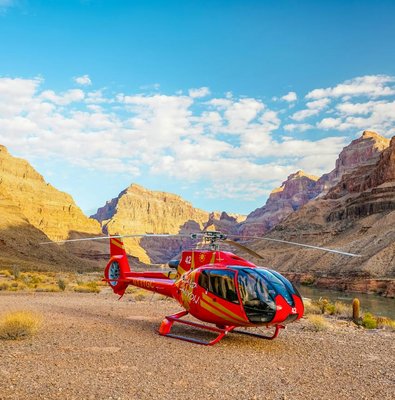 Helicopter on the Grand Canyon floor with canyon walls in the background.